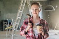 Portrait of happy young female construction worker, carpenter, repairman standing in workshop wearing safety glasses Royalty Free Stock Photo