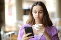 Serious woman checking phone drinking in a bar Royalty Free Stock Photo