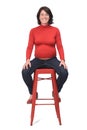 Front view of a pregnant woman sitting on a stool on white background Royalty Free Stock Photo