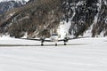 A front view of a private jet ready to take off in the snow covered landscape and mountains in hte alps switzerland in winter Royalty Free Stock Photo