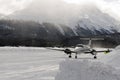 A front view of a private jet ready to take off in the snow covered landscape and mountains in hte alps switzerland in winter Royalty Free Stock Photo