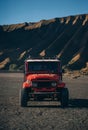 Front view of red jeep with Bromo volcano background