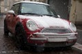 Front view of red mini cooper covered by the sbow parked in the street Royalty Free Stock Photo