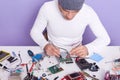 Front view of repairman using special instrument and showing process of mobile phone repair in service center, radioman wears Royalty Free Stock Photo