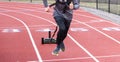 Front view of a runner pulling a sled with weights on a track Royalty Free Stock Photo