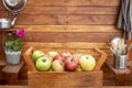 Front view of a rustic wooden home corner with a basket full of apples on the table. Many vitamins together and a mix of colors