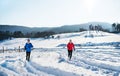 A front view of senior couple jogging in snowy winter nature.