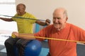 Senior man exercising with resistance band in fitness studio Royalty Free Stock Photo