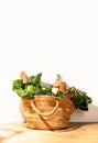 Front view of shopping straw bag full of fresh leafy vegetables. Healthy food ingredients shopping concept Royalty Free Stock Photo