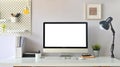 Front view shot of creative Work space. White blank screen computer on Office working desk. Equipment on table. Royalty Free Stock Photo