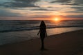 Front view silhouette of attractive woman. Beautiful young girl with long hair walking on the beach, posing at sunset Royalty Free Stock Photo