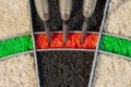A sisal dartboard with three darts in triple twenty sector