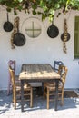 Front view of small cafe exterior. Table and empty chairs outdoor near the white wall. Tourist places. Typical Mediterranean Royalty Free Stock Photo