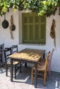 Front view of small cafe exterior. Table and empty chairs outdoor near the white wall. Tourist places. Typical Mediterranean Royalty Free Stock Photo