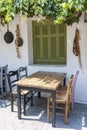 Front view of small cafe exterior. Table and empty chairs outdoor near the white wall. Tourist places. Typical Mediterranean Royalty Free Stock Photo