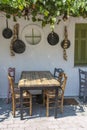 Front view of small cafe exterior. Table and empty chairs outdoor near the white wall. Tourist places. Typical Mediterranean Royalty Free Stock Photo