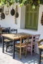 Front view of small cafe exterior. Table and empty chairs outdoor near the white wall. Tourist places. Typical Mediterranean Royalty Free Stock Photo