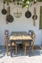 Front view of small cafe exterior. Table and empty chairs outdoor near the white wall. Tourist places. Typical Mediterranean Royalty Free Stock Photo