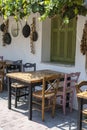 Front view of small cafe exterior. Table and empty chairs outdoor near the white wall. Tourist places. Typical Mediterranean Royalty Free Stock Photo