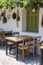 Front view of small cafe exterior. Table and empty chairs outdoor near the white wall. Tourist places. Typical Mediterranean Royalty Free Stock Photo