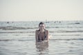 Front view of a smiling woman with wet hair wearing swimsuit lying in sea during summer vacations Royalty Free Stock Photo