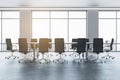 Front view of spacious empty conference room with office desk and chairs, window with city view, white walls and concrete floor. Royalty Free Stock Photo