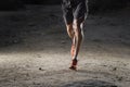 Sport man with ripped athletic and muscular legs running off road in jogging training workout at countryside in Autumn background