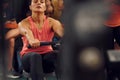 Front view. Sportive woman doing exercises on rowing machine in the gym