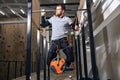 Muscled sportsman with physical disability performing pull ups with load