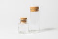 Front view of transparent empty glass jar or test tube bottles with closed brown cork cap lids on white background Royalty Free Stock Photo