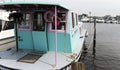 Front view of a tropical colored houseboat moored in a marina