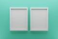 Front view of two empty white picture frames on wall, background biscay green, minimal design concept, 3D render Royalty Free Stock Photo