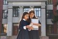 Front view. Two schoolgirls is outside together near school building Royalty Free Stock Photo