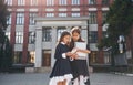 Front view. Two schoolgirls is outside together near school building Royalty Free Stock Photo