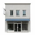 Front View of a Two- Story Brick Building with Blue and White Striped Awning and Glass Doors Royalty Free Stock Photo