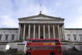 Front view of University College London main building with a double decker bus and beautiful sky