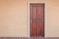 Front view vintage brown wooden door on red brick wall. Royalty Free Stock Photo