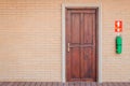 Front view vintage brown wooden door on red brick wall. Royalty Free Stock Photo