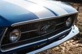 Front view of a vintage blue Ford Mustang with horse riding logo in exhibition cars