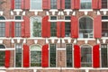 Front view of vintage windows with red wooden shutters of traditional house Royalty Free Stock Photo
