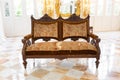 Front view of vintage wooden sofa in luxury mirror room or hall decorated with chandelier Royalty Free Stock Photo