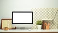 Front view of white blank screen computer monitor, picture frame, pencil holder and houseplant on working table Royalty Free Stock Photo