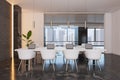 Front view on white chairs near big white meeting table with modern laptops on dark marble floor in stylish conference room with Royalty Free Stock Photo