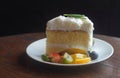 Front view white Coconut cake and strawberry, kiwi, orange slices, blueberry on a white plate, on a wooden table, dessert, food, Royalty Free Stock Photo