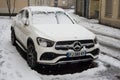 Front view of white Mercedes SUV car covered by the snow parked in the street Royalty Free Stock Photo