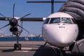 Front view of white modern turboprop airliner with close-up of pointed nose with cockpit windows, black six-bladed Royalty Free Stock Photo