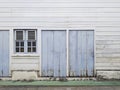 Front view of white old wooden tropical house facade, blue doors and windows. Architecture and construction background. Typical Royalty Free Stock Photo