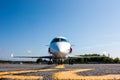 Front view of white private business jet at the parking lot of airport