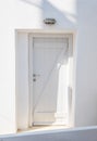 Front view of white wooden door in a white wall Royalty Free Stock Photo
