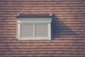 Front view of white wooden window on rooftop of wooden house in vintage style at countryside.